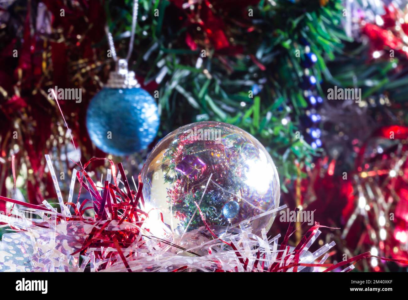 Decorazioni di Natale su un albero attraverso la sfera di obiettivo, macro sparato primo piano Foto Stock