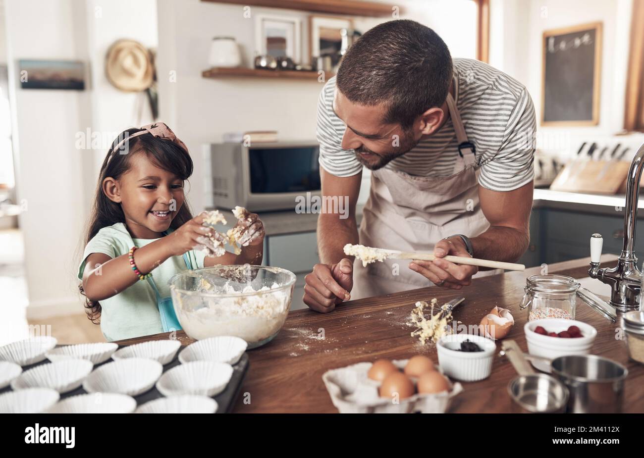 Le famiglie sono come un fudge per lo più dolce, con qualche noce. un padre insegna a sua figlia come cuocere in cucina a casa. Foto Stock