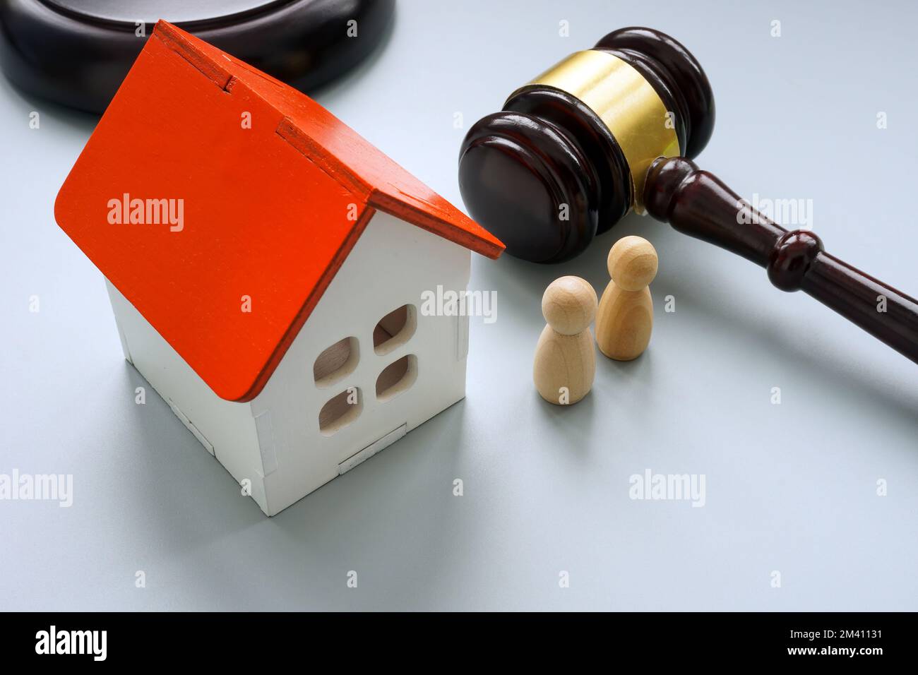 Modello di casa con due figure e gavel. Concetto di separazione o di eredità. Foto Stock