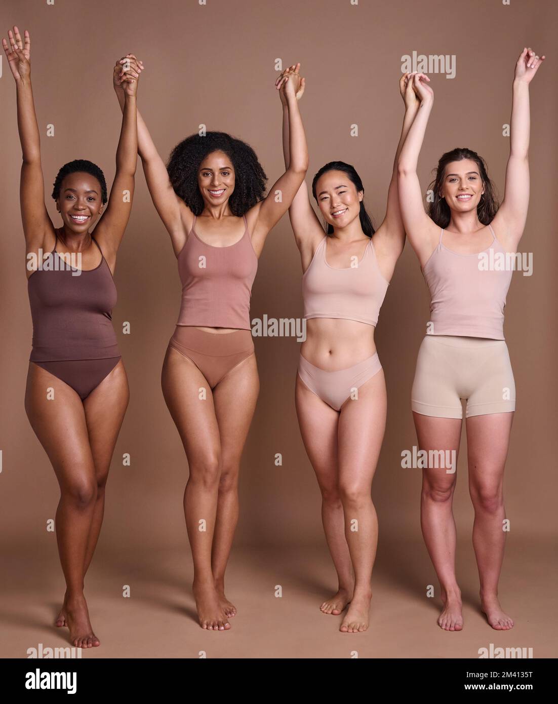 Donne diversità, positività del corpo e celebrazione del colore della pelle di gruppo di amici modello tenendo le mani. Bellezza, fiducia e comunità femminile per la cura della pelle Foto Stock