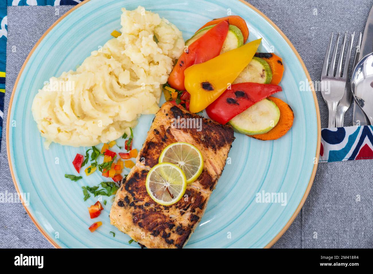Pasto a la carte con bistecca di salmone con verdure e purè di patate al tavolo del ristorante Foto Stock