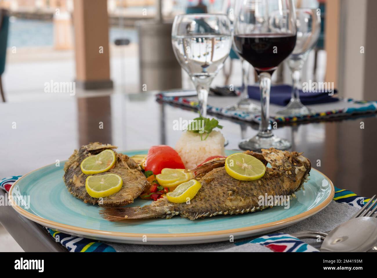 Pasto a la carte a base di pesce alla griglia con riso bianco al vapore sul piatto al tavolo del ristorante Foto Stock