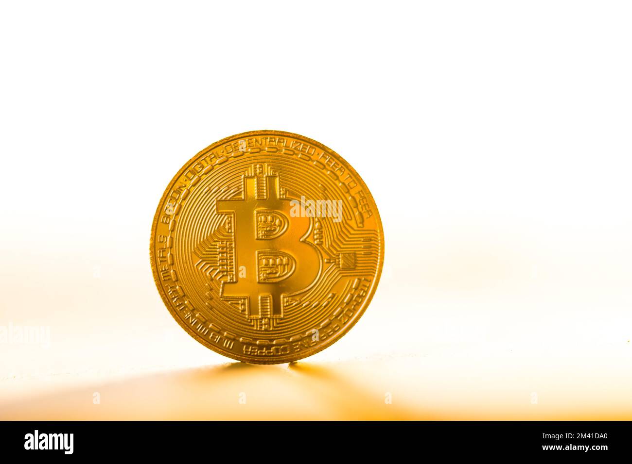 Moneta bitcoin oro posta su sfondo bianco alla luce del tramonto. Simbolo  valuta virtuale Foto stock - Alamy
