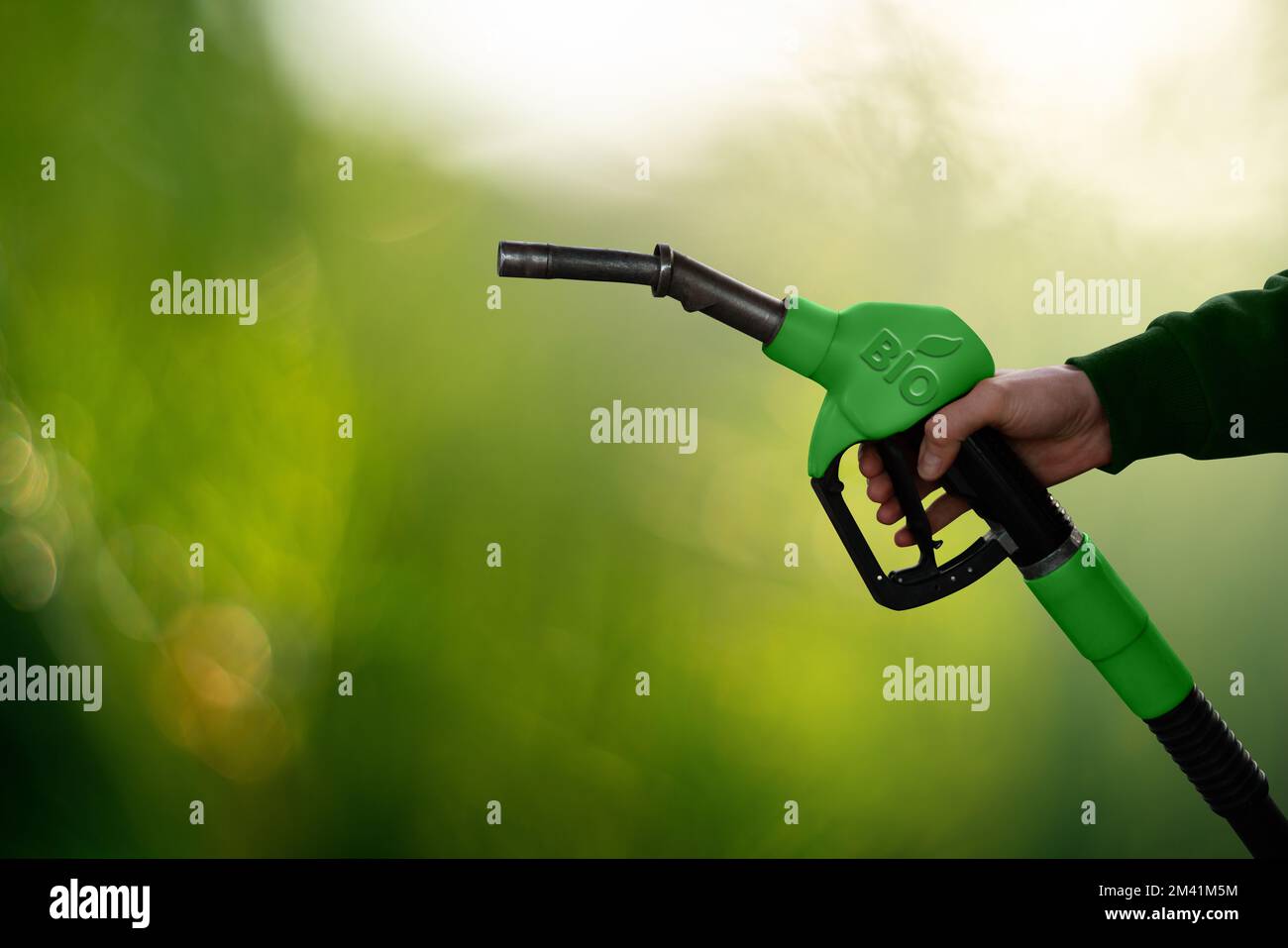 Mano con ugello del carburante con iscrizione BIO. Concetto di decarbonizzazione del carburante biologico a emissioni di carbonio neutre Foto Stock