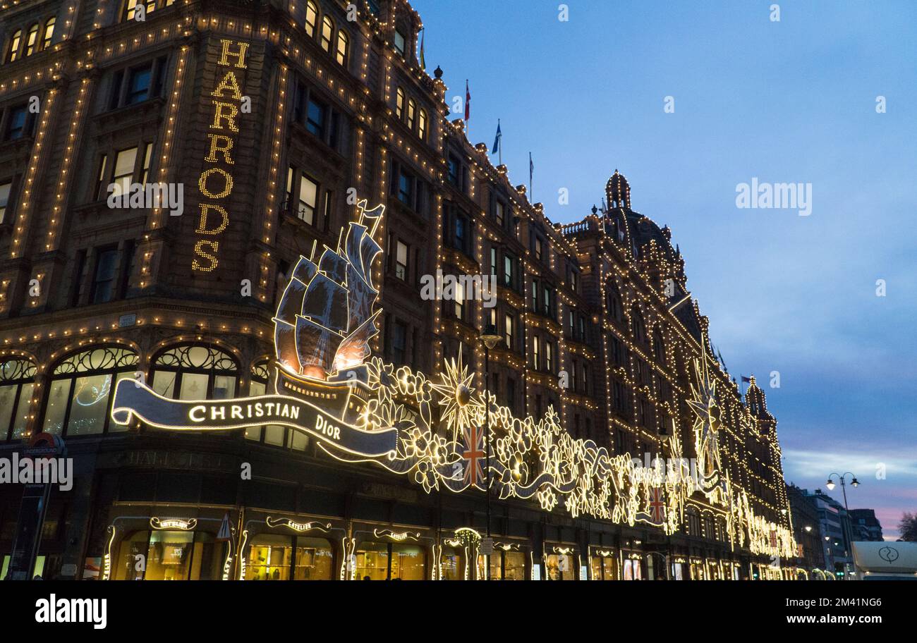 Londra, Regno Unito, 17 dicembre 2022: Nonostante lo sciopero ferroviario, molte persone si trovavano a Londra per vedere le luci di Natale mentre facevano i loro acquisti. Mentre il sole tramonta, le luci a tema di Christian Dior sul grande magazzino Harrods si sono spesse contro il cielo crepuscolo. Anna Watson/Alamy Live News Foto Stock