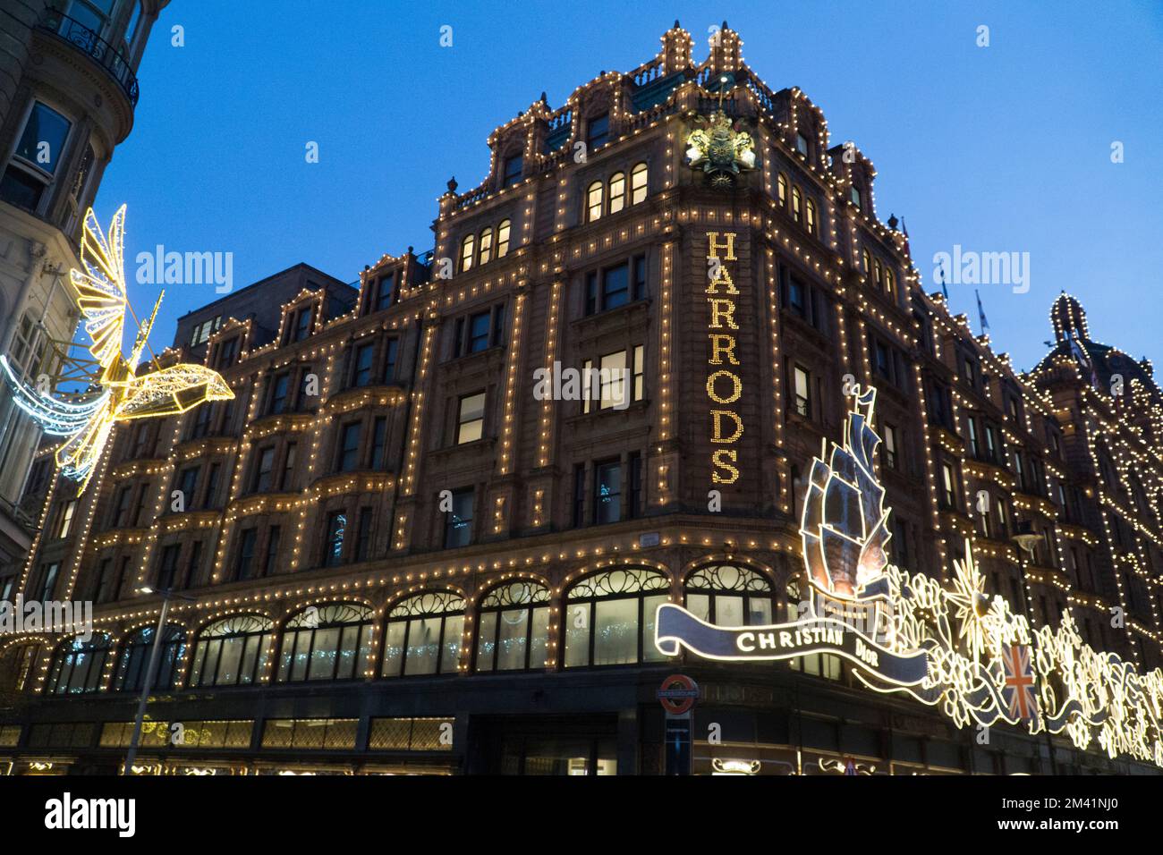 Londra, Regno Unito, 17 dicembre 2022: Nonostante lo sciopero ferroviario, molte persone si trovavano a Londra per vedere le luci di Natale mentre facevano i loro acquisti. Mentre il sole tramonta, le luci a tema di Christian Dior sul grande magazzino Harrods si sono spesse contro il cielo crepuscolo. Anna Watson/Alamy Live News Foto Stock