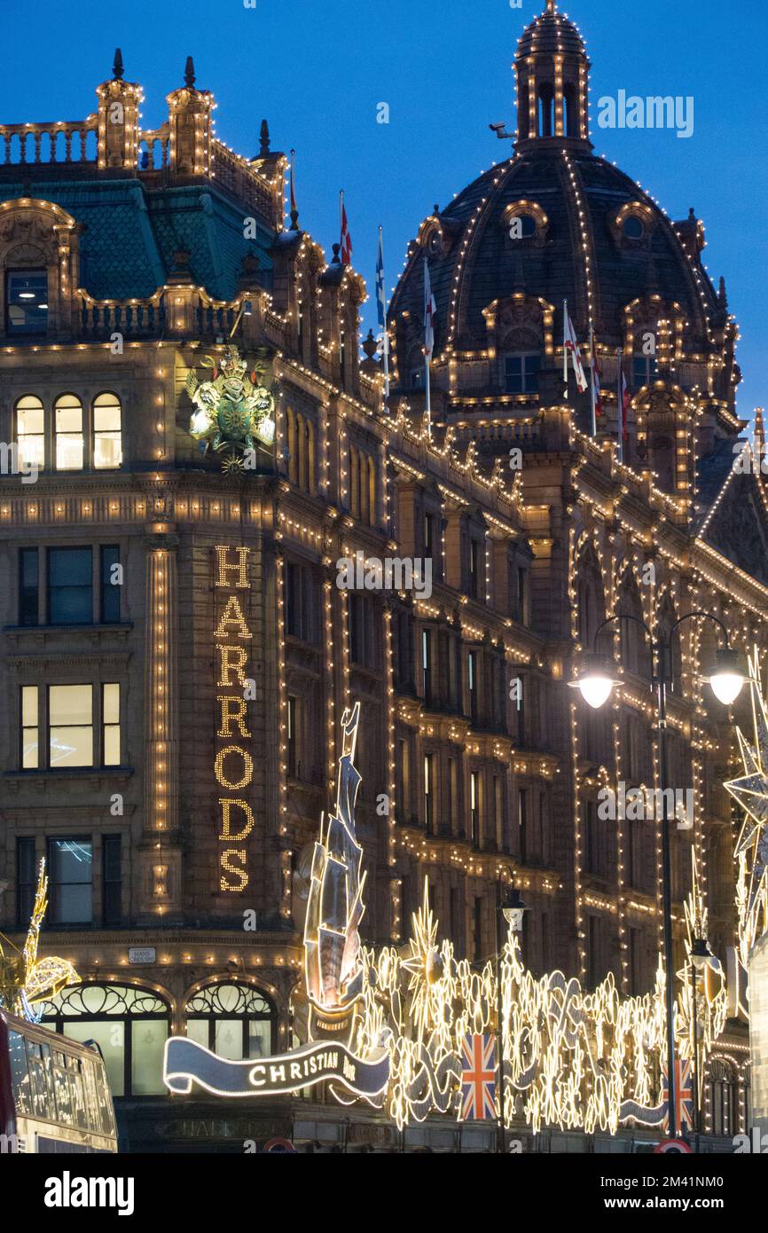 HARRODS Shopping di Natale SHOPPERS LONDRA magazzini Harrods al tramonto  con le luci di Natale shopping folle e macchine passando Knightsbridge  London SW1 Foto stock - Alamy