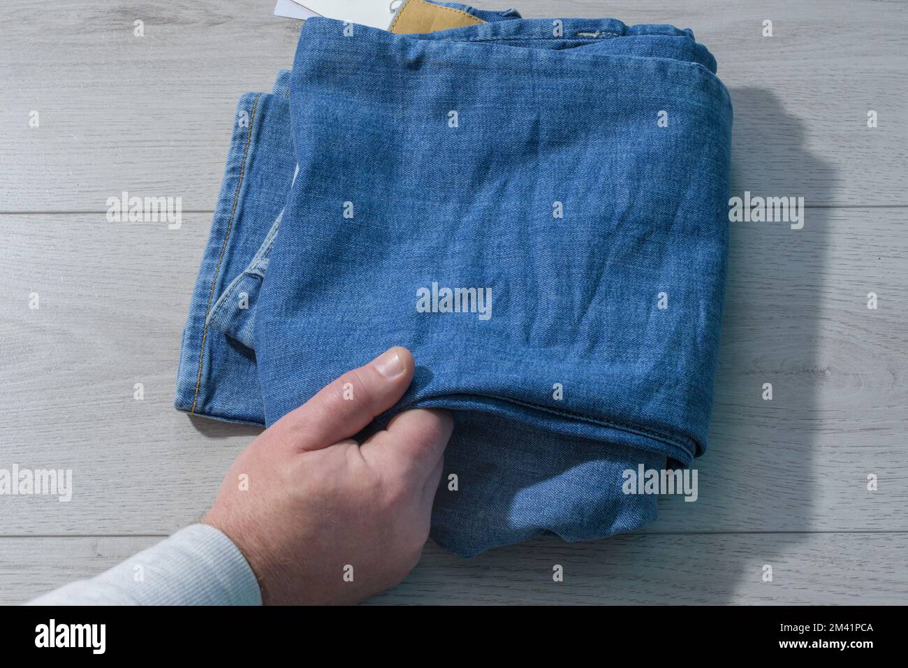 Jeans blu. L'acquirente verifica la qualità dei pantaloni in denim. Controllare le cose Foto Stock