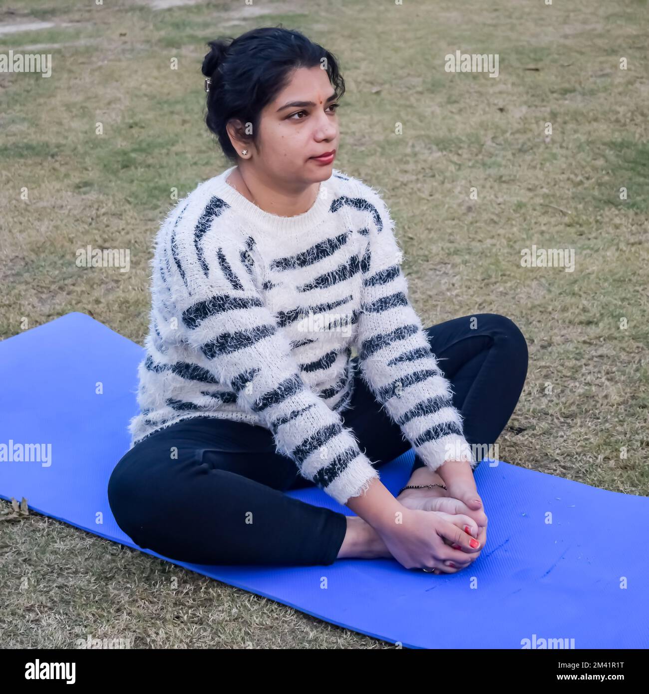Ritratto di una splendida giovane donna indiana che pratica yoga all'aperto in un parco. Bella ragazza pratica yoga di base posa. Calma e relax, happine femminile Foto Stock