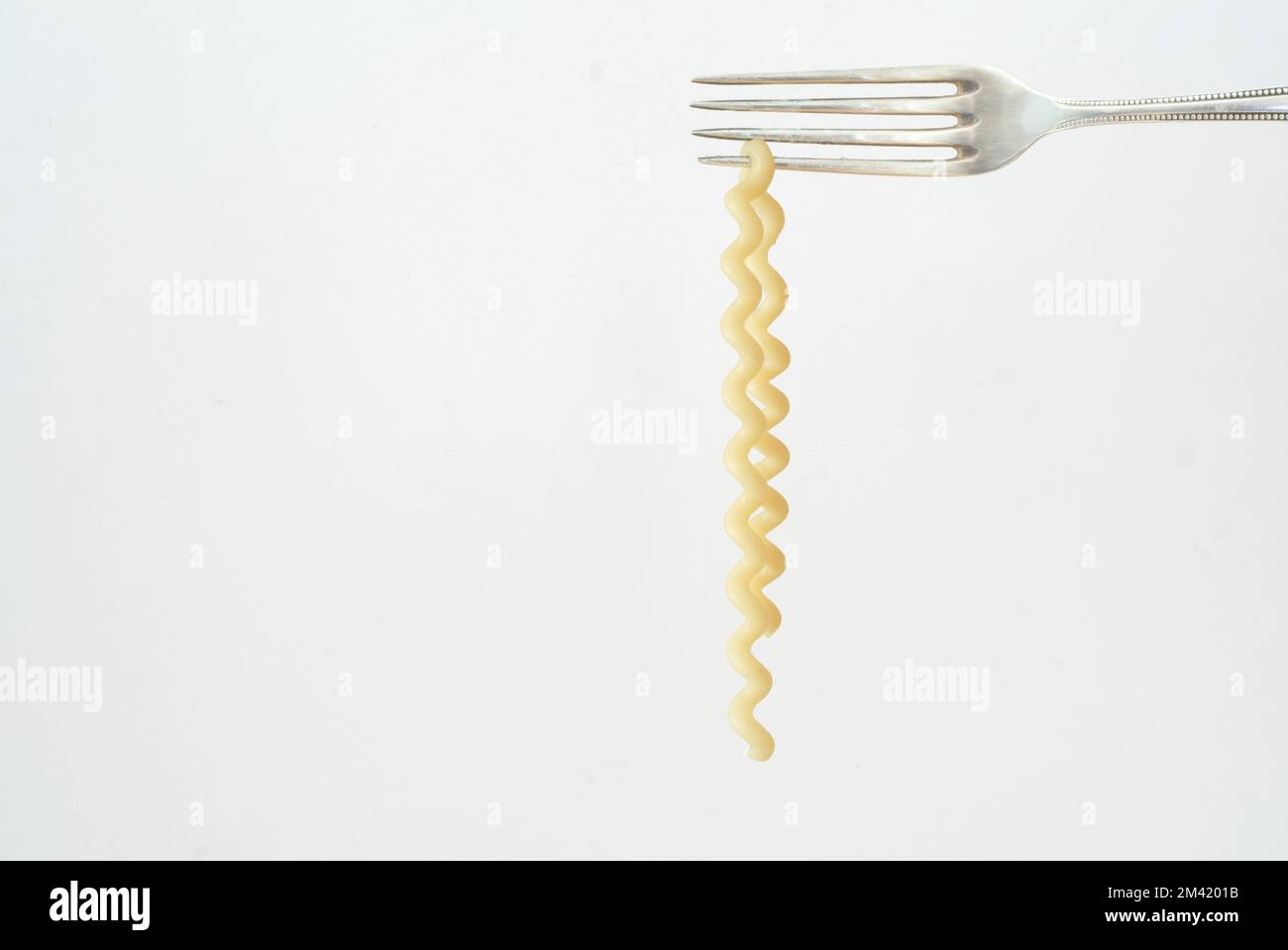 pasta italiana appesa ad una forchetta d'argento, isolata su sfondo bianco, spazio copia libero Foto Stock
