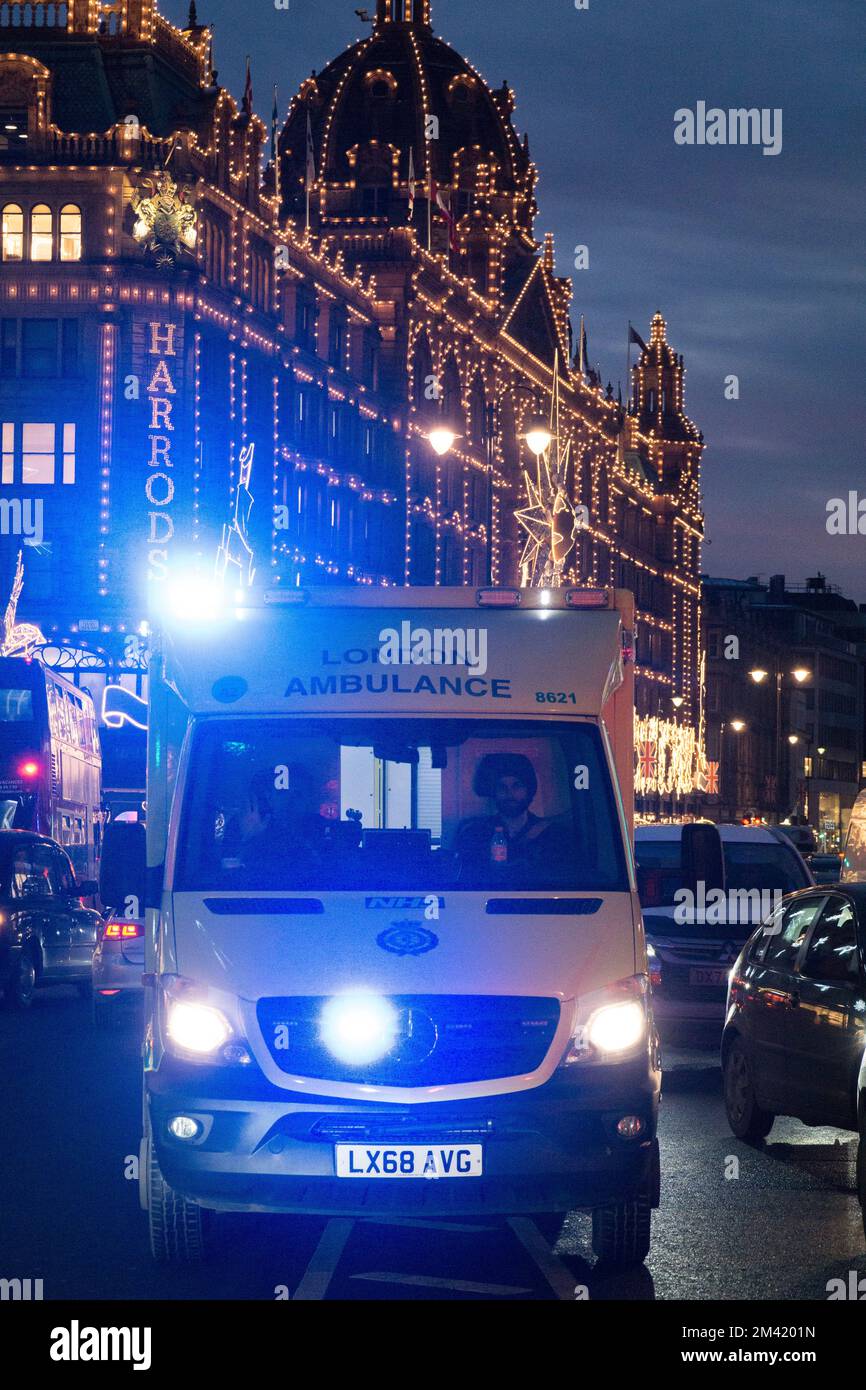 Londra, Regno Unito, 17 dicembre 2022: Un'ambulanza di emergenza lo fa attraversare il traffico pesante a Knightsbridge, con le luci di Natale sullo sfondo. In Inghilterra e Galles i conducenti di ambulanze dei sindacati GMB, Unison e Unite dovranno scioperarsi il 21 dicembre in una disputa sulla retribuzione. Anna Watson/Alamy Live News Foto Stock