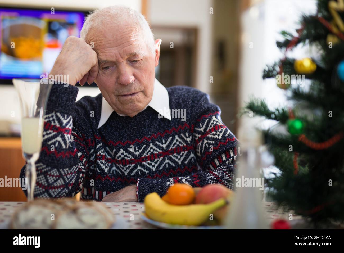 Ritratto di un anziano solitario stanco al tavolo della cena durante la celebrazione di natale Foto Stock