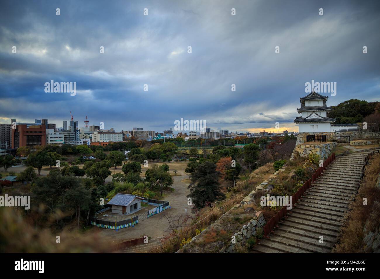 Nuvole tempesta sopra la torre panoramica del castello di Akashi al tramonto Foto Stock