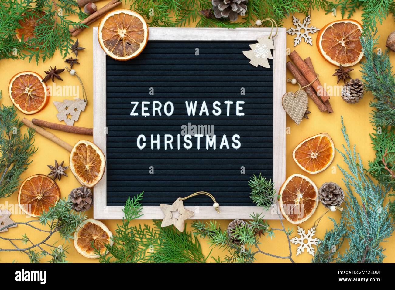 Concetto di Natale senza sprechi. Materiali naturali legno, carta, rami di abete, coni, noci, agrumi secchi, cannella. Cornice con iscrizione. Eco- Foto Stock