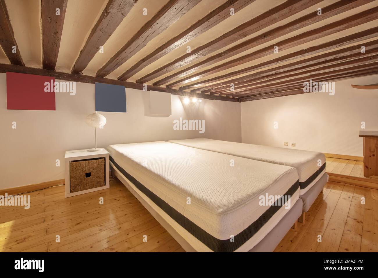 Camera su soppalco con soffitti con travi in legno e materassi senza letti Foto Stock