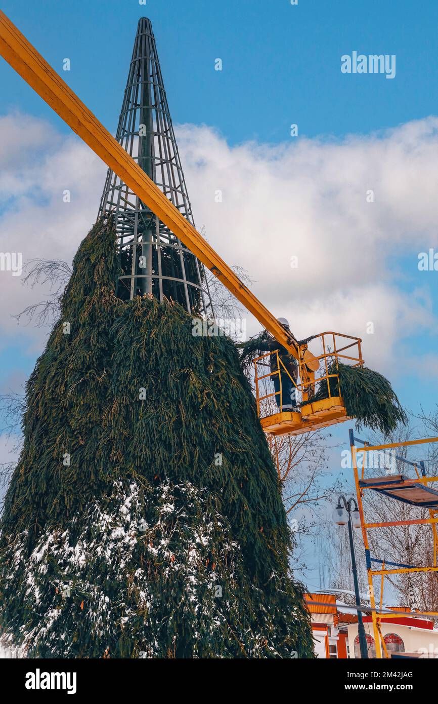 Fare un albero di Natale su una cornice di metallo in inverno dai lavoratori Foto Stock