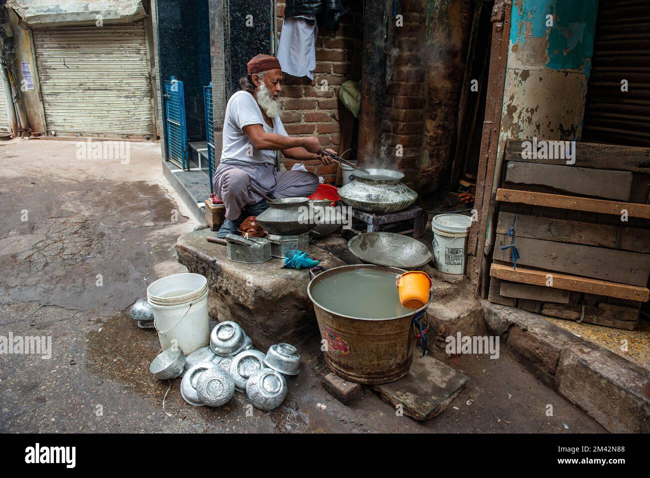 Vecchia Delhi, India. 18th Dec, 2022. Un kalaiwala o re-tinner ripara gli utensili tradizionali dell'ottone e del rame al suo negozio in Delhi vecchia. (Credit Image: © immagini Pradeep Gaur/SOPA tramite ZUMA Press Wire) Foto Stock