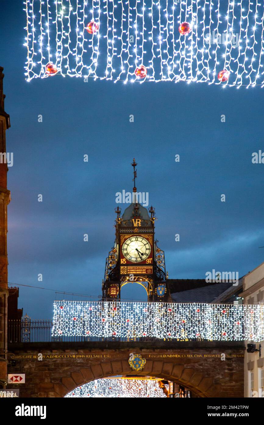 Vista dell'orologio vittoriano di Eastgate e della torre dell'orologio che si erge sulle mura romane della città di Eastgate Street Chester durante le luci di Natale del 2022 Foto Stock