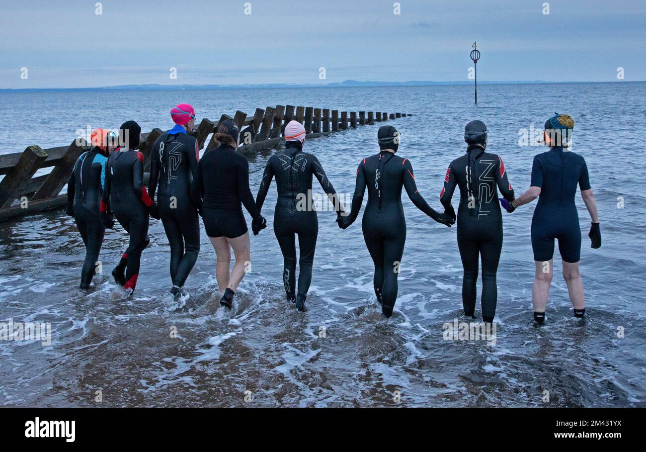 Portobello, Edimburgo, Scozia, Regno Unito. 18th dicembre 2022. Una sfida di nuoto dalla Norvegia allo Shetland per i Samaritani a causa del loro ruolo vitale nella prevenzione del suicidio. Questa mattina un gruppo di amici ha sfidato il Firth of Forth, la spiaggia di Portobello a Edimburgo, Una nuotata all'alba in memoria di Michael Findlay, che è tragicamente morto poco più di un anno fa. Gli amici nuotano per beneficenza a distanza da Bergen a Lerwick, circa 370km km, in mare e piscine. Il fundraiser è stato avviato per i samaritani venerdì scorso e collettivamente come gruppo hanno swum oltre 40k del target 370k. Credito: ArchWhite Foto Stock