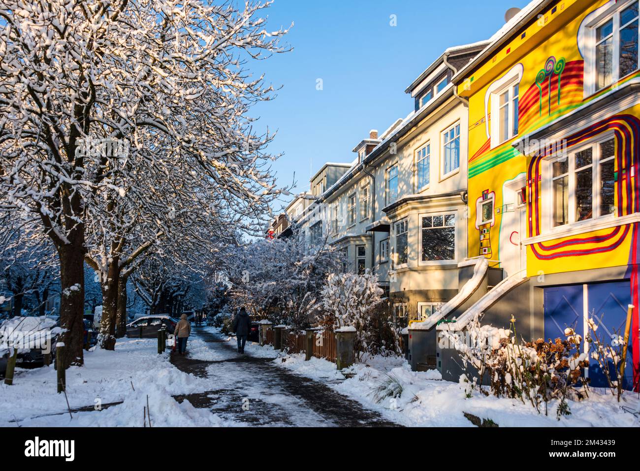 Bunte Häuserfassade mit verschneiten Bäumen im Dezember Foto Stock