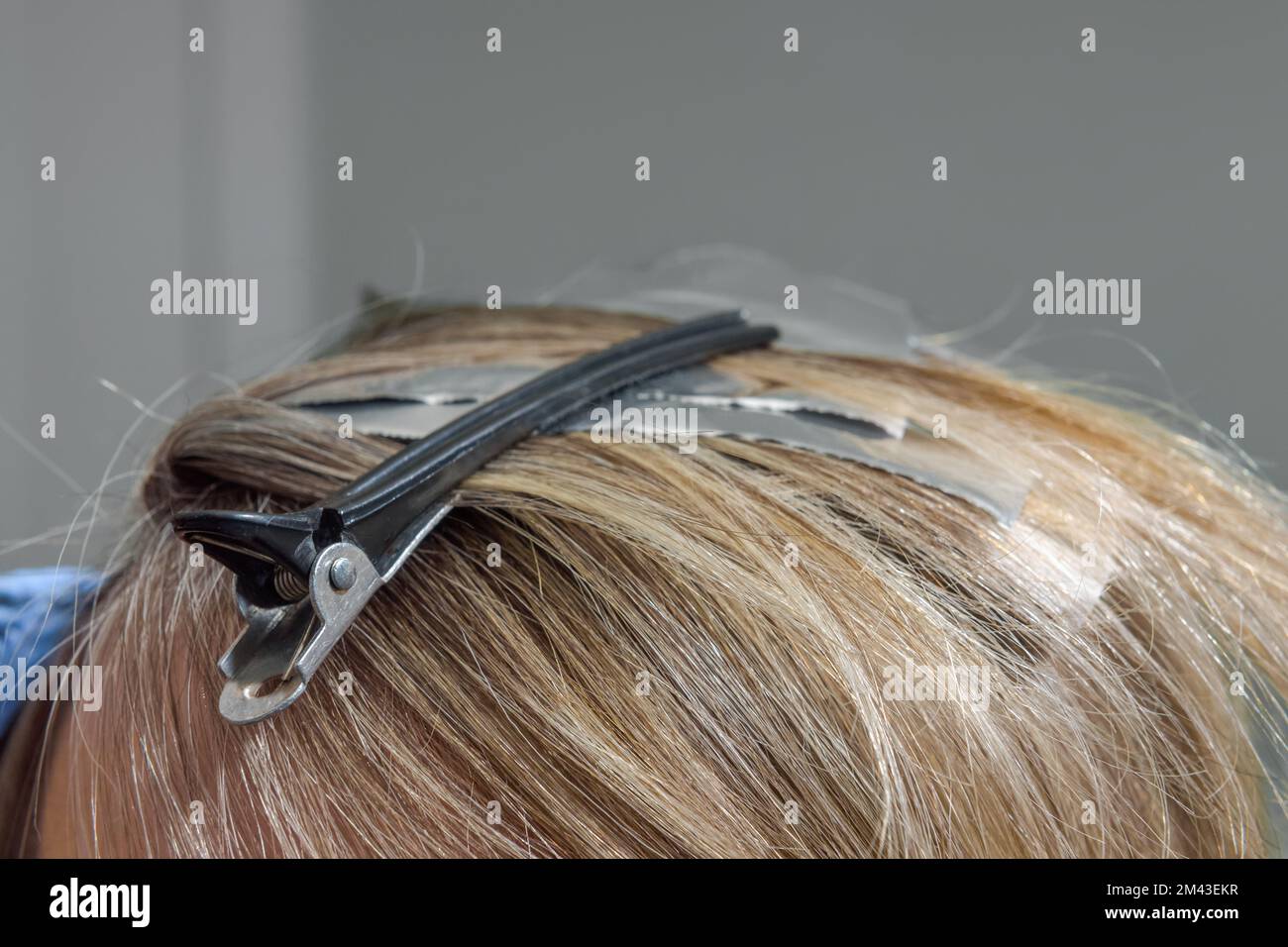Processo di colorazione dei capelli. uso di pellicola. messa a fuoco selezionata. struttura dei capelli Foto Stock