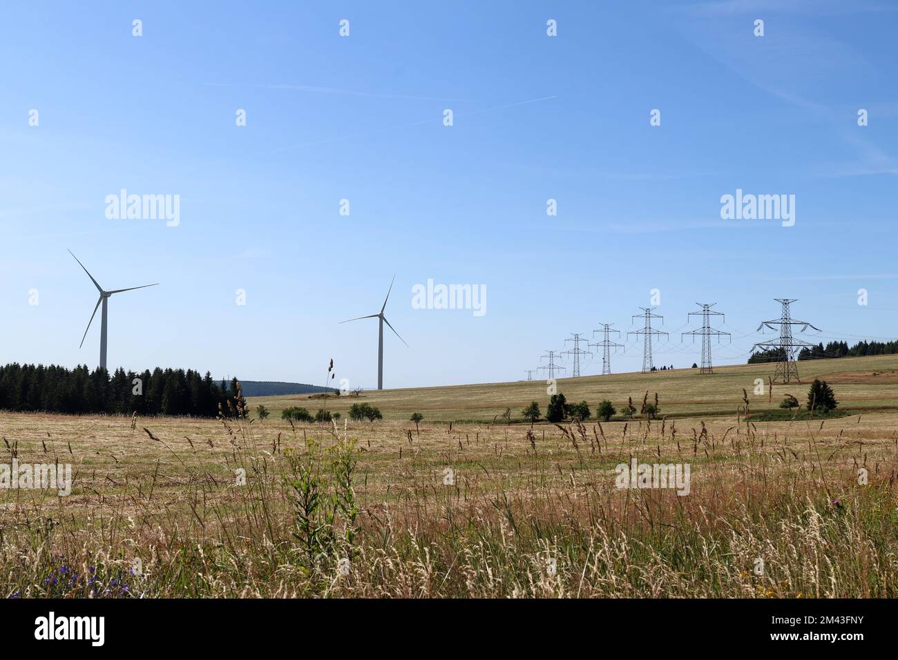 Linee elettriche ad alta tensione e centrali eoliche nel paesaggio montano Foto Stock