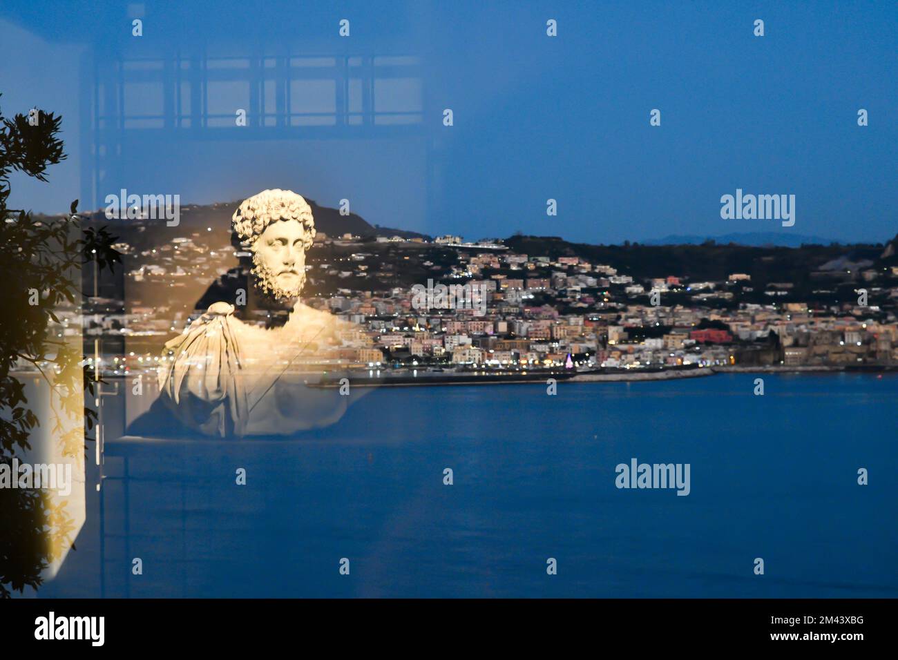 Un'antica statua romana riflessa su un vetro nel museo di storia romana di Bacoli, città italiana. Foto Stock