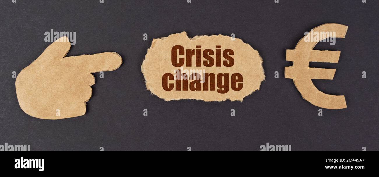 Economia e finanza. Su una superficie nera, una figura di una mano, un simbolo dell'euro e un cartone strappato con l'iscrizione - Crisis Change Foto Stock
