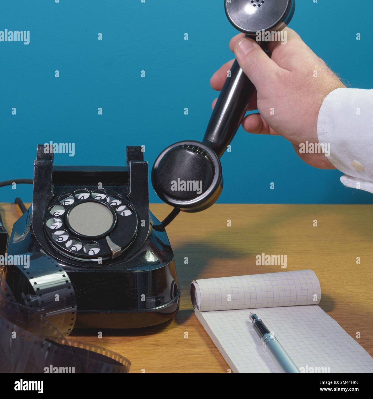 Prendi il telefono. Vecchio apparecchio telefonico su un tavolo di legno, blocco note, penna inchiostro Foto Stock