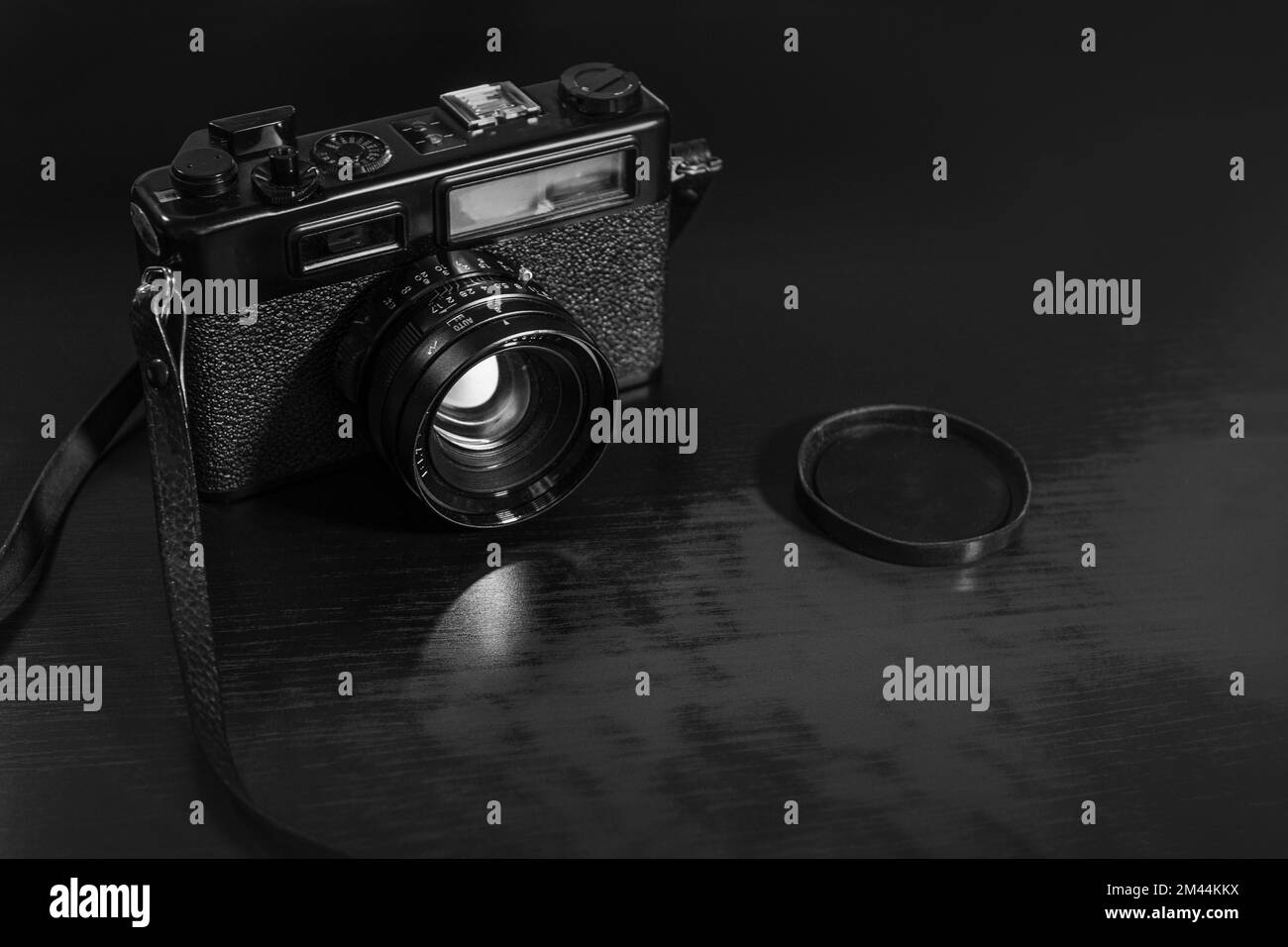 Fotocamera retro su sfondo tavolo in legno, vintage - bianco e nero Foto Stock