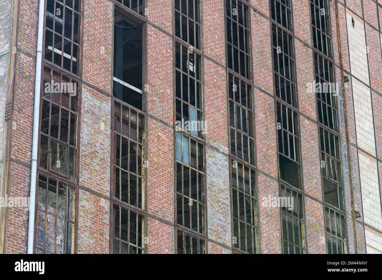 Facciata di fabbrica abbandonata. Finestre arrugginite senza vetro. Foto Stock