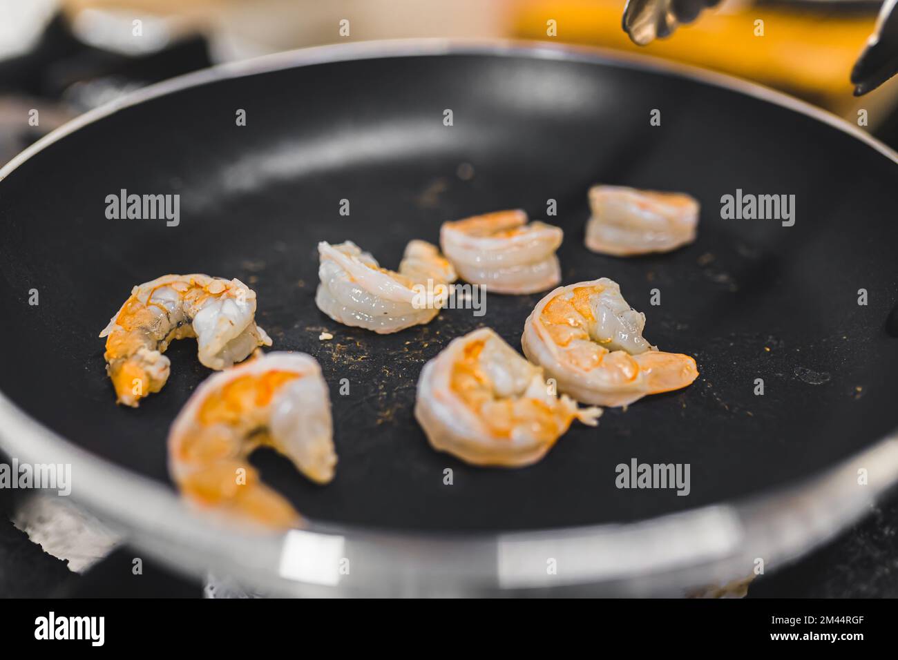 Piccoli gamberetti in padella. Preparazione di un piatto da ristorante. Pesce e mangiare fuori concetto. Foto di alta qualità Foto Stock