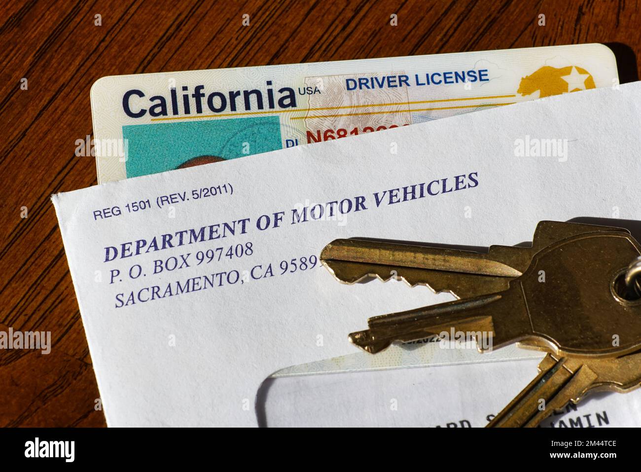 Lago Elsinore, California, USA: 18 dicembre 2022: Primo piano della patente di guida californiana in busta con le chiavi dell'auto. Foto Stock