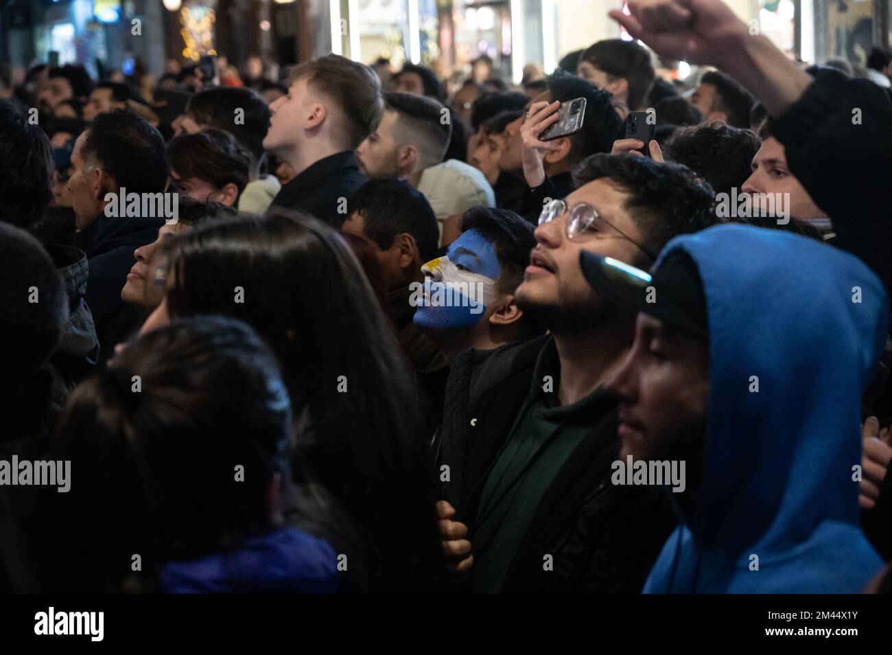 Madrid, Spagna. 18th Dec, 2022. Tifosi argentini che guardano la partita finale tra Argentina e Francia in strada su uno schermo di un bar. L'Argentina ha vinto la Coppa del mondo FIFA Qatar 2022 sconfiggendo la Francia in una partita che si è conclusa con un pareggio di 3-3, vincendo il titolo di campionato dopo le penalità (4-2). Credit: Marcos del Mazo/Alamy Live News Foto Stock