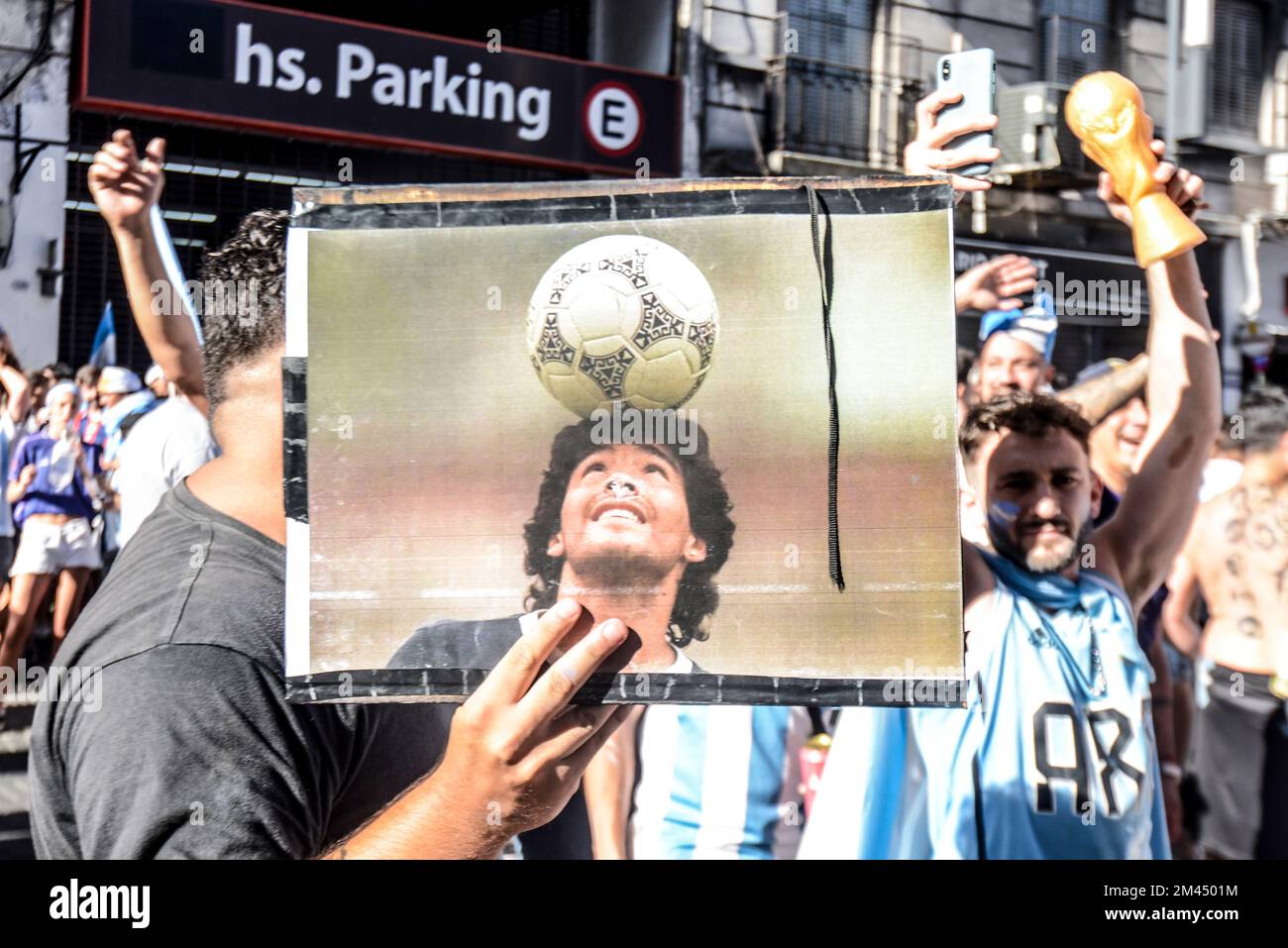 I fan argentini di Buenos Aires festeggiano la loro squadra sconfiggendo la Francia per vincere la Coppa del mondo 2022, con un ritratto di Diego Maradona Foto Stock