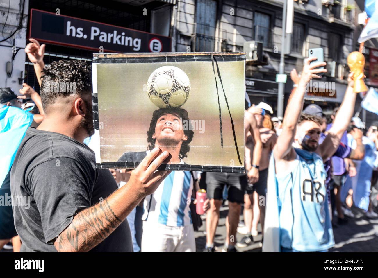 I fan argentini di Buenos Aires festeggiano la loro squadra sconfiggendo la Francia per vincere la Coppa del mondo 2022, con un ritratto di Diego Maradona Foto Stock