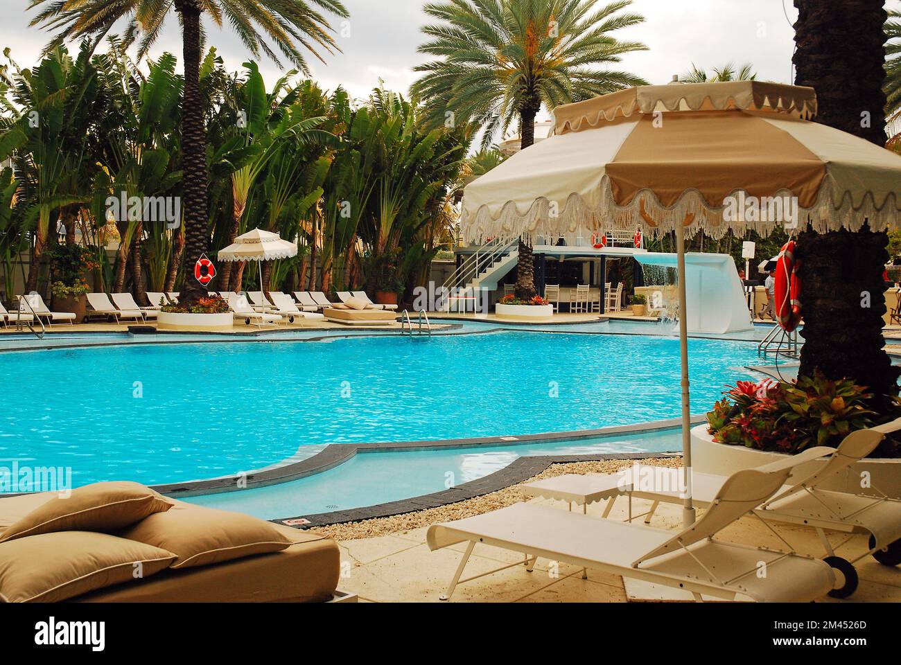 Un ombrello a bordo piscina offre una rilassante vista vacanza al Raleigh Hotel e resort a South Beach, Miami, Florida Foto Stock
