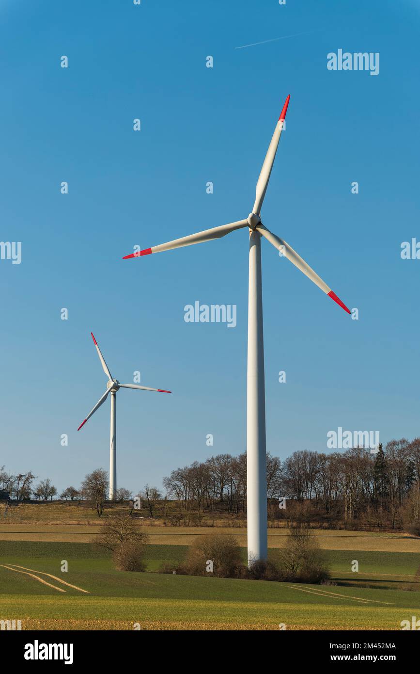 Gruppo di turbine eoliche contro un cielo blu luminoso in un paesaggio rurale, adatto come immagine simbolica per le energie rinnovabili, vicino a Höxter, Weserbergland Foto Stock
