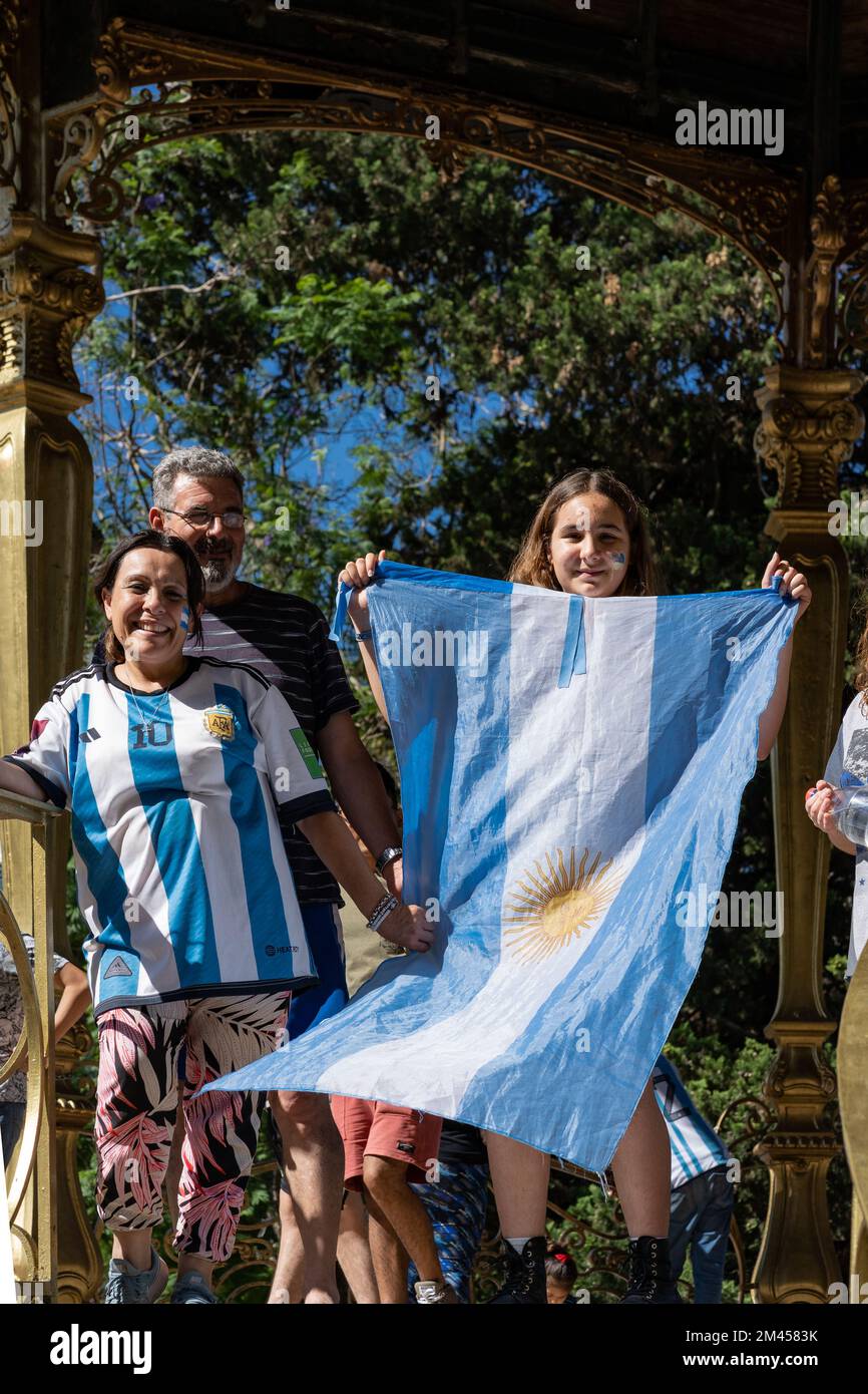 La Plata, Buenos Aires, Argentina - 18 dicembre 2022: Una ragazza con una bandiera argentina e la sua famiglia festeggia che l'Argentina ha vinto la Coppa del mondo FIFA 2022 Foto Stock