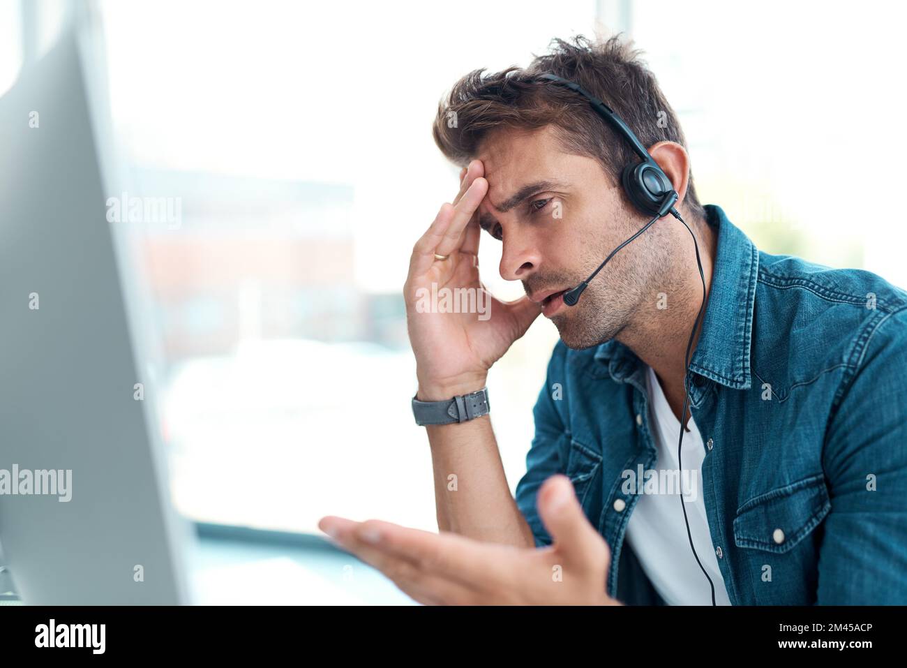 Youre essere irragionevole ora. un giovane operatore del call center che si è arrabbiato mentre lavora in ufficio. Foto Stock