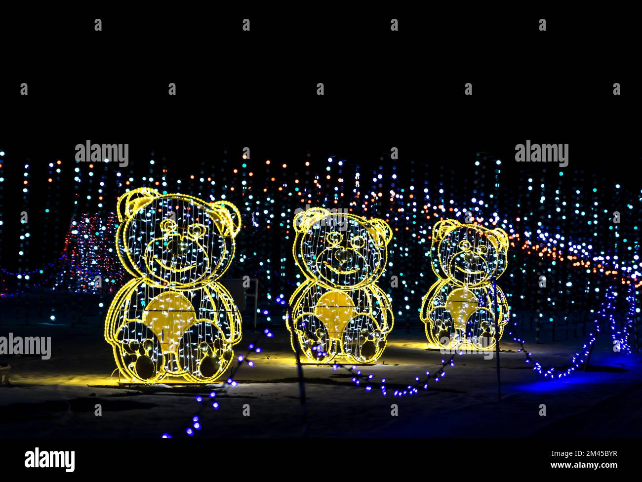 Colorate decorazioni natalizie strisce di luci LED contro il cielo notturno Foto Stock