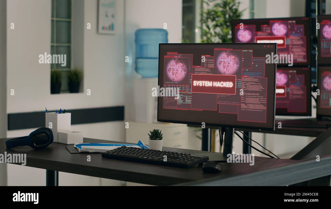 Computer che visualizzano un avviso di attacco di pirateria informatica e una violazione della sicurezza in un ufficio di sviluppo IT vuoto. Visualizzazione del messaggio di errore critico lampeggiante sullo schermo dopo un arresto anomalo del sistema, avviso di pericolo. Foto Stock
