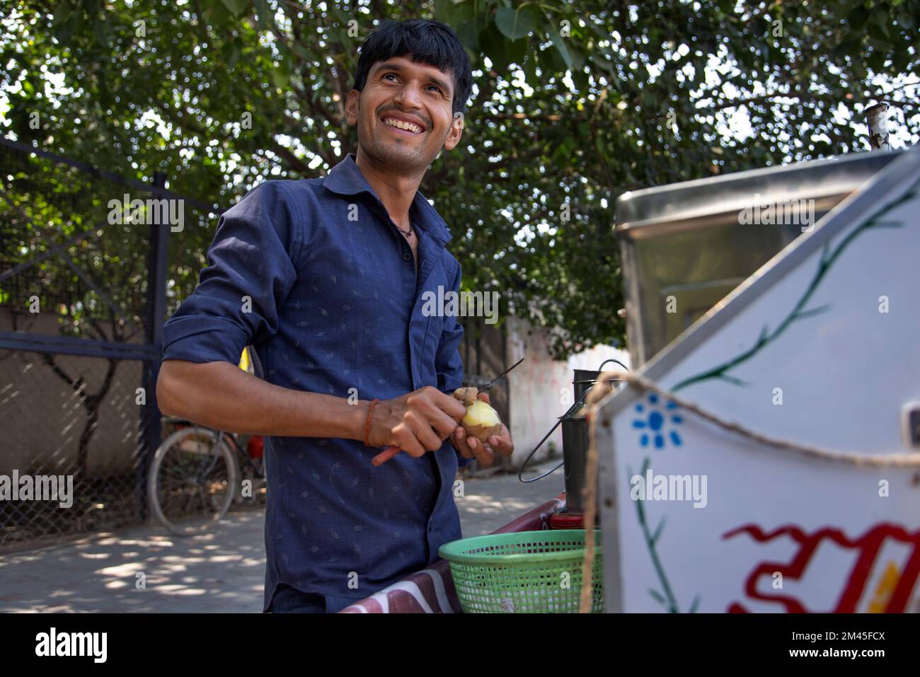 Ritratto di un venditore maschio sorridente che si spacca la patata Foto Stock