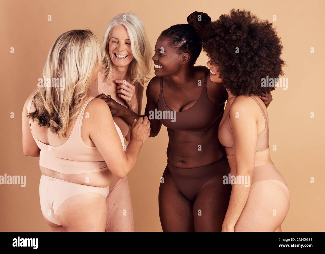 Diversità, donne e cura della pelle per la positività del corpo, il benessere e parlare su sfondo marrone studio. Cosmetici, donne o multirazziale Signore conversazione Foto Stock