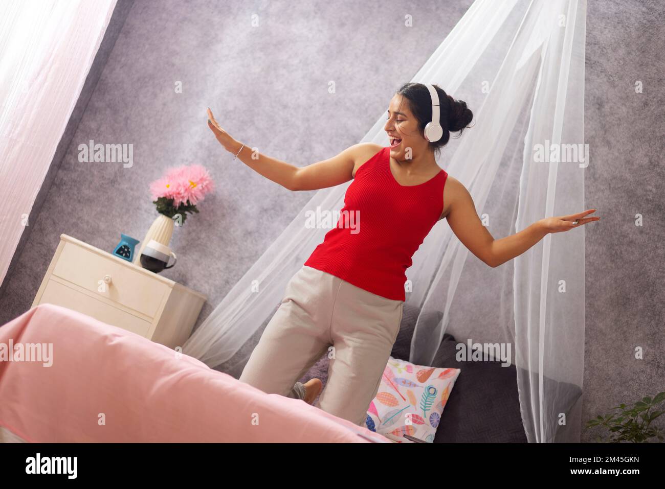 Ritratto di una bella ragazza adolescente godendo la musica in camera da letto Foto Stock