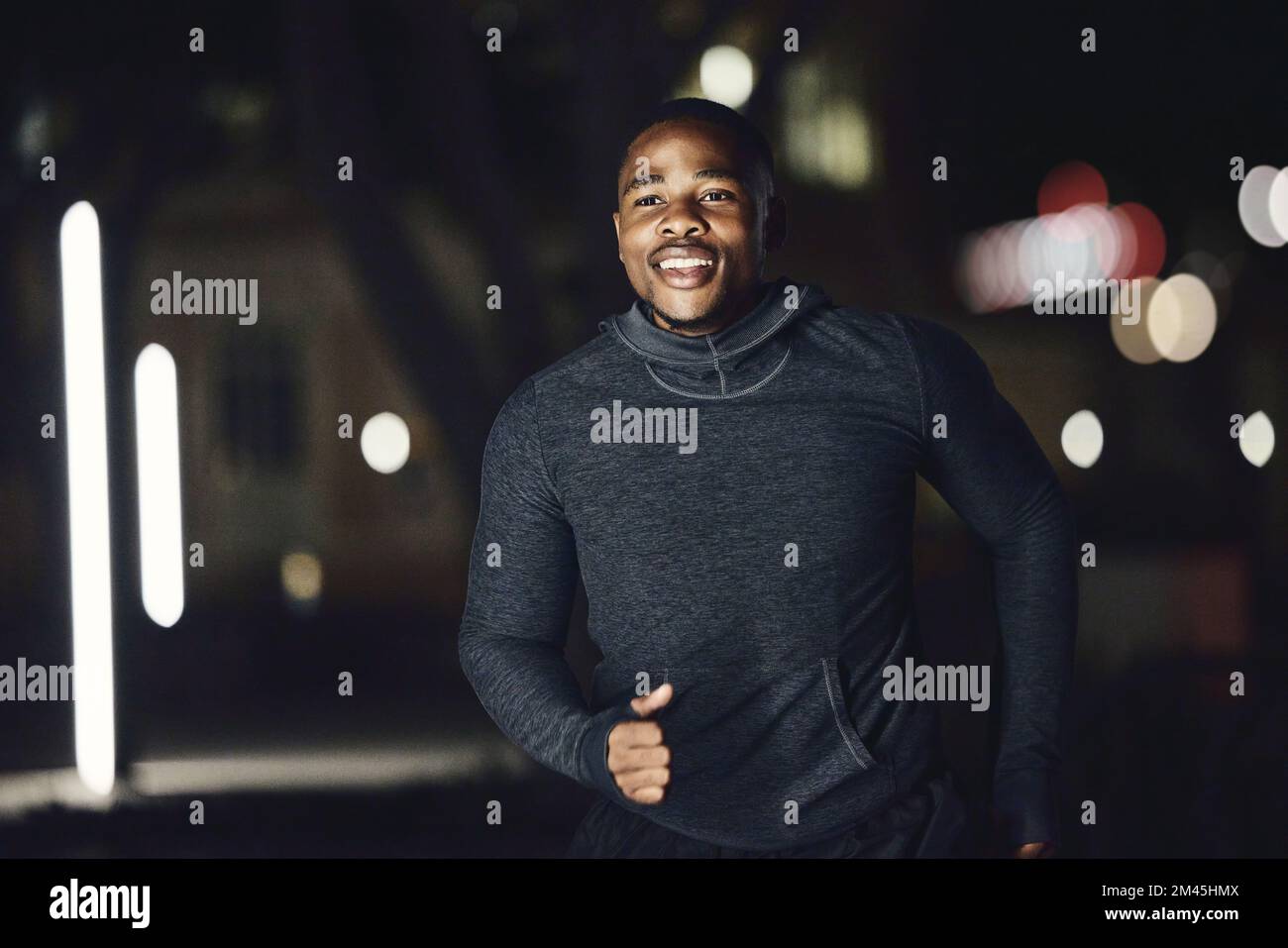 Runner, salute o fitness uomo nero di notte correre in città, strada o strada per l'allenamento maratona, gara o allenamento. Felice, sorridente o sportivo Foto Stock