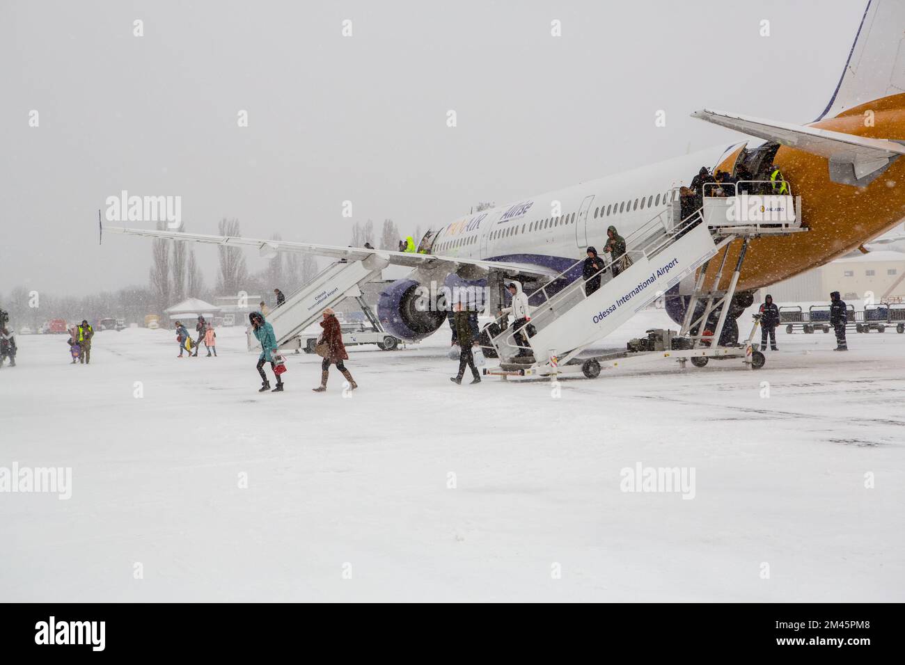 Odessa, Ucraina - CIRCA 2018: Aereo passeggeri in aeroporto in inverno in Blizzard. Passeggeri che atterrano in aereo in inverno durante la tempesta di neve. Camera moderna con letti gemelli Foto Stock