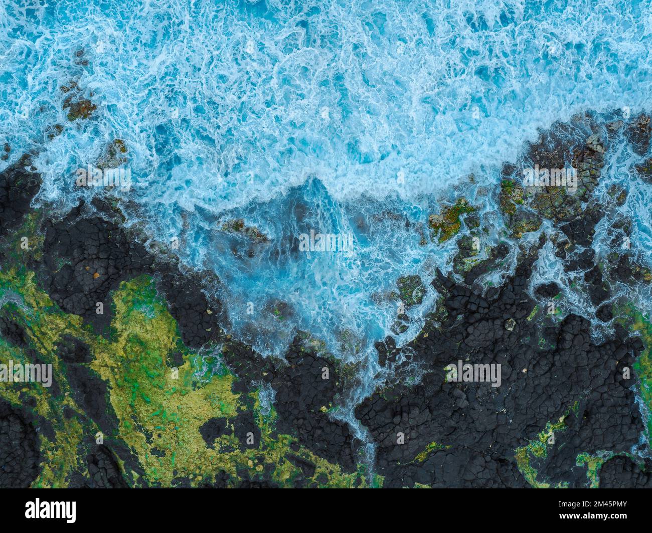 Incredibili rocce nere sulla costa. Onde infrangenti sulle scogliere. il potere naturale della terra madre è sulla foto. formazioni geologiche spiandiate Foto Stock