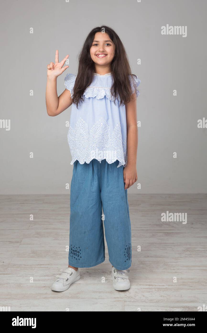Ritratto di una giovane ragazza araba che fa un segno a mano. Foto Stock
