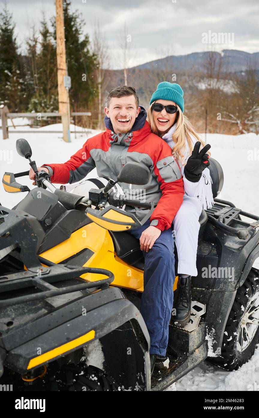 Ritratto di felice uomo e donna in posa su fuoristrada quattro ruote ATV. Concetto di attività ricreative e invernali. Foto Stock